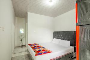 une petite chambre avec un lit dans une pièce dans l'établissement Hotel O Wongso Residence Syariah, à Pangkal Pinang