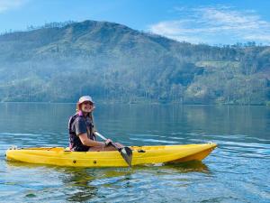 a woman sitting in a yellow kayak on a lake at The Farm Resorts in Hatton
