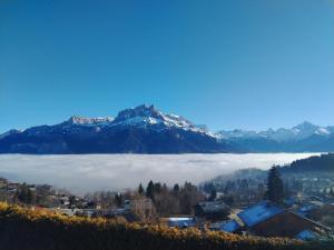 a mountain shrouded in clouds with a town and a city at Chalet-Hôtel Les Rhodos in Cordon