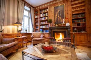 a living room with a fireplace and a table at Hotel Niederländischer Hof in Schwerin