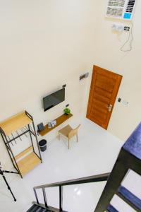 a room with a bed and a tv and a chair at Coastal Breeze Hotel in Baler