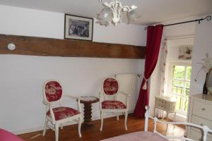 a living room with two chairs and a table at Chambres d'hôtes du vieil hêtre in Mantilly