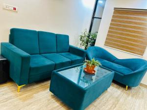 a blue couch and a coffee table in a living room at Mystay suites in Bengaluru