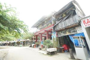 图隆阿贡OYO 93628 Scorpion Guest House & Beach的路边有招牌的建筑物