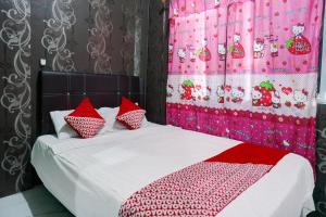 une chambre avec un lit avec des oreillers rouges et blancs dans l'établissement Hotel O Penginapan Pelangi, à Batam Center 17 autres photos