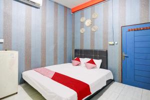 - une chambre avec un lit et une porte bleue dans l'établissement Hotel O Penginapan Pelangi, à Batam Center