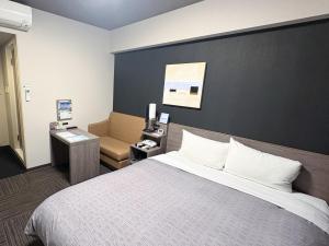 a hotel room with a bed and a chair at Hotel Route-inn Utsunomiya Yuinomori -Lightline Yuinomori Nishi Ekimae- in Utsunomiya +27 photos