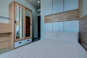 una camera da letto con un grande letto bianco con testiera in legno di OYO Life 93289 Jelita Residence 2 a Semarang Altre 21 foto