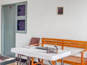 a table with a bird statue on it next to a bench at Hotel O Kost Naura in Sungguminasa