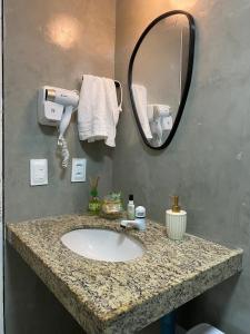 a bathroom with a sink and a mirror at Studio Beira Mar Piscina Cobertura Localização perfeita Jatiúca in Maceió
