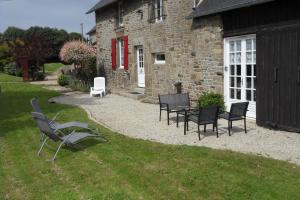 a group of chairs sitting in the grass in front of a building at Chambres d'hôtes du vieil hêtre in Mantilly