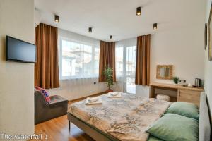 um quarto com uma cama e uma televisão em The Waterfall Free Parking em Balchik