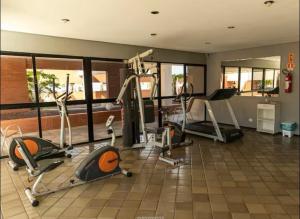a gym with several treadmills and elliptical machines at Studio Beira Mar Piscina Cobertura Localização perfeita Jatiúca in Maceió