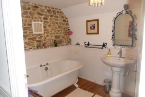 a bathroom with a bath tub and a sink at Chambres d'hôtes du vieil hêtre in Mantilly +20 photos