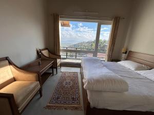 a hotel room with two beds and a large window at VAAS Cottage in Mukteshwar