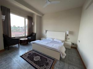 a bedroom with a bed and a large window at VAAS Cottage in Mukteshwar