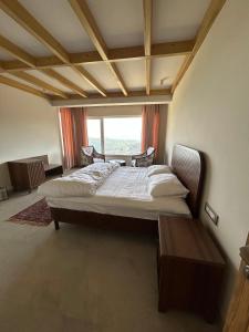 a bedroom with a large bed and a window at VAAS Cottage in Mukteshwar