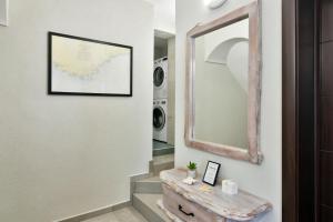 um corredor com um espelho e uma mesa com uma mala em The Waterfall Free Parking em Balchik mais 26 fotografias