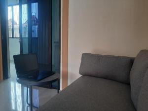 a laptop sitting on a table next to a couch at Capital O 93719 Homestay Omah Bidadari in Prambanan +14 photos