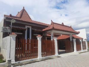 a house with a gate and a roof at Capital O 93719 Homestay Omah Bidadari in Prambanan