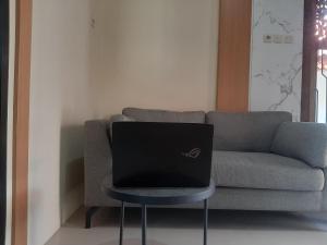 a laptop computer sitting on a chair in front of a couch at Capital O 93719 Homestay Omah Bidadari in Prambanan