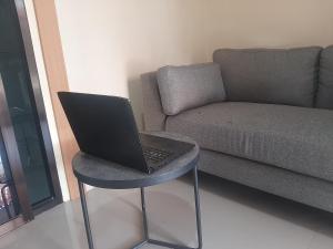 a laptop sitting on a stool next to a couch at Capital O 93719 Homestay Omah Bidadari in Prambanan