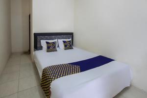 - une chambre dotée d'un lit blanc avec des oreillers bleus et jaunes dans l'établissement SPOT ON 93724 Songgong Homestay, à Kuta Lombok 19 autres photos