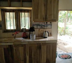 a kitchen with wooden cabinets and a counter top at Milk House Mirissa, Entire Home, Authentic Village in Mirissa