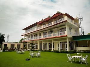 a large building with chairs and tables on a lawn at Skyview Stays I Party Lawns I Adjacent The Good Club I 1km Sukhna lake,Rock Garden & High Court I in Chandīgarh