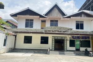 a building with a motorcycle parked in front of it at Hotel O Aglo Homestay NearYani Heahlerr in Rantau