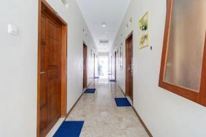 a hallway with blue mats on the floors and doors at Hotel O Siwalanpanji Homestay Syariah in Sidoarjo +22 photos