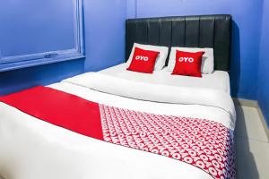 two beds with red pillows in a blue room at Hotel O Iconiq Rooms in Bekasi