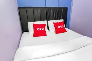 a bed with two red pillows on it at Hotel O Iconiq Rooms in Bekasi +26 photos