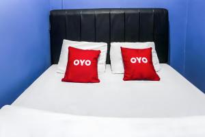 two red pillows sitting on top of a bed at Hotel O Iconiq Rooms in Bekasi