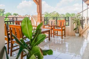 un balcon avec des chaises, une table et une plante dans l'établissement Hotel O Buduran Homestay Syariah, à Sidoarjo 21 autres photos