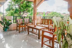 une rangée de chaises et de tables sur un balcon dans l'établissement Hotel O Buduran Homestay Syariah, à Sidoarjo