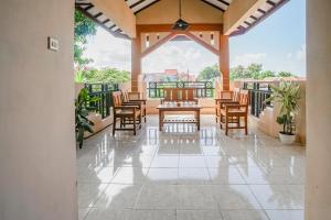 un patio avec tables et chaises sur un balcon dans l'établissement Hotel O Buduran Homestay Syariah, à Sidoarjo