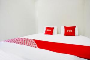 un letto rosso e bianco con due cuscini rossi di Hotel O Sejolie Sibayak a Berastagi