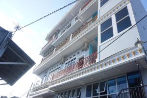 a white building with a balcony on the side of it at Hotel O Pondok Bintang in Kendari