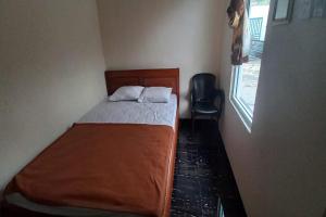 a small bedroom with a bed and a window at Hotel O 45 Guest House in Sragen