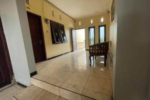 a hallway of a house with a chair and doors at Hotel O 45 Guest House in Sragen