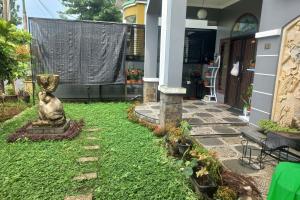a statue sitting in the yard of a house at Hotel O Salma Homestay Syariah Near alun alun kota purwokerto in Purwokerto
