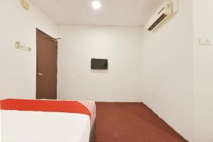 a room with a bed and a tv on the wall at Hotel O Gest Inn in Kota Tinggi +33 photos
