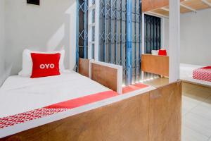 a bedroom with a bed with a red pillow at Hotel O Wonosobo Bunkbed in Wonosobo