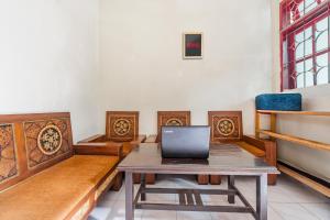 a room with a table with a laptop on it at Hotel O Regina Homestay Syariah in Surabaya +25 photos