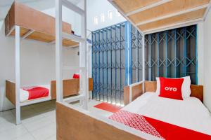 a bedroom with two bunk beds and a red pillow at Hotel O Wonosobo Bunkbed in Wonosobo