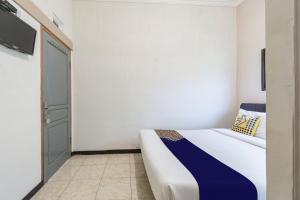 a bedroom with a bed with a blue and white blanket at Hotel O 3n Homestay Syariah in Sidoarjo