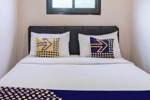 a bed with blue and yellow pillows on it at Hotel O 3n Homestay Syariah in Sidoarjo