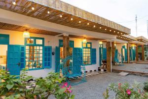 a building with blue shuttered windows and awnings at Thuy Tien Mui Ne Homestay BBQ Free in Mui Ne