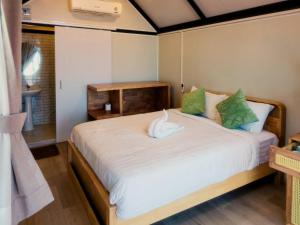 a bedroom with a large white bed with green pillows at Jayden Villas in Hinkong